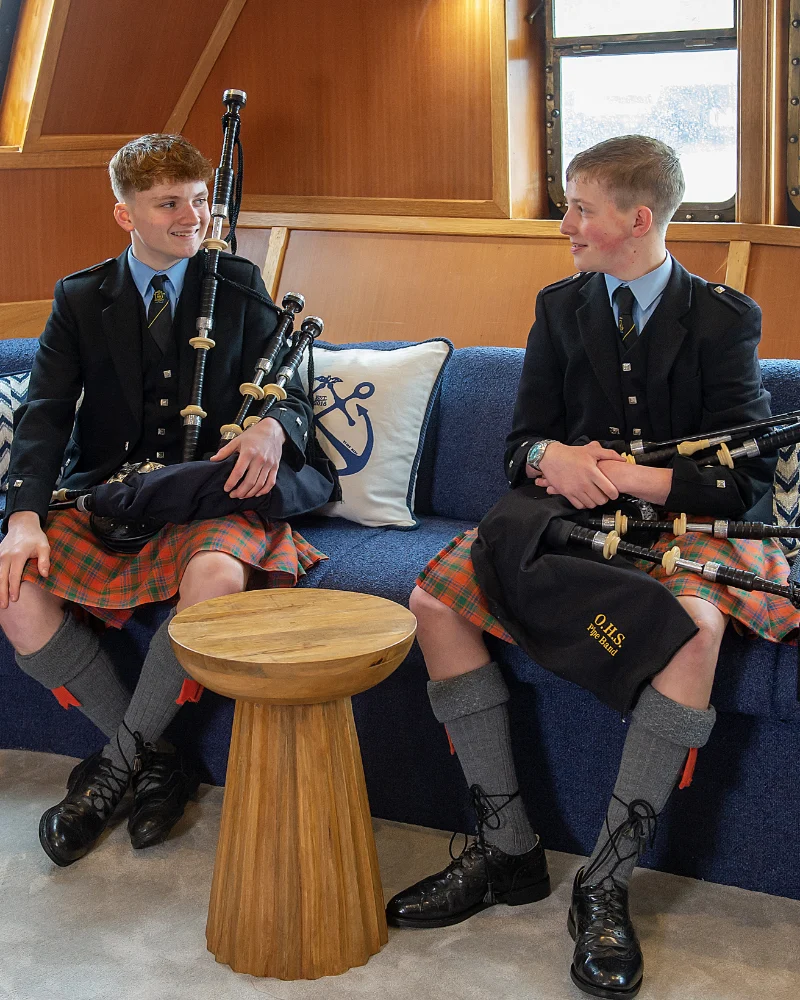 2 men dressed in kilts holding bagpipes