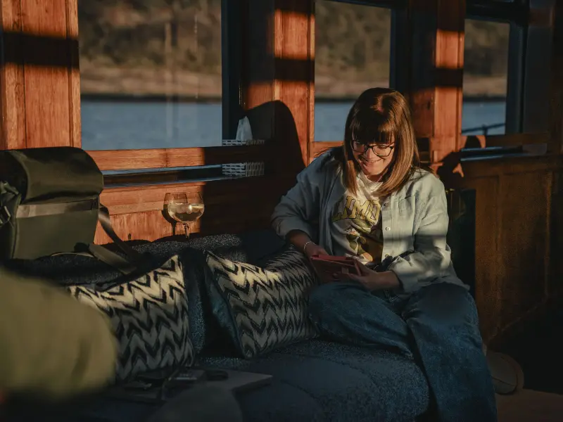 Person sitting inside one of our vessels on their iPad
